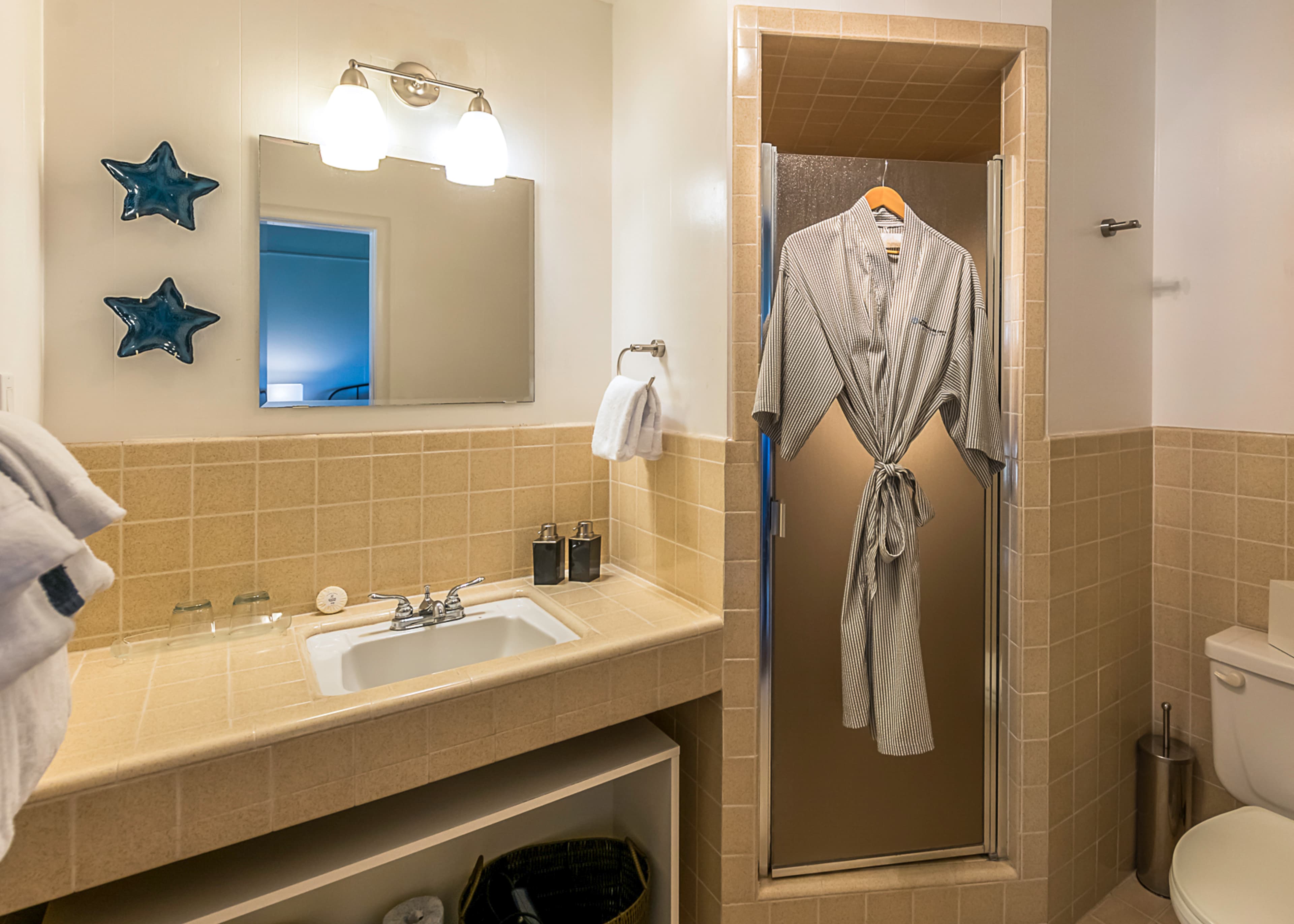 Buckhorn Bathroom with a sink, toilet, and shower. A robe hangs on a hook beside the shower.